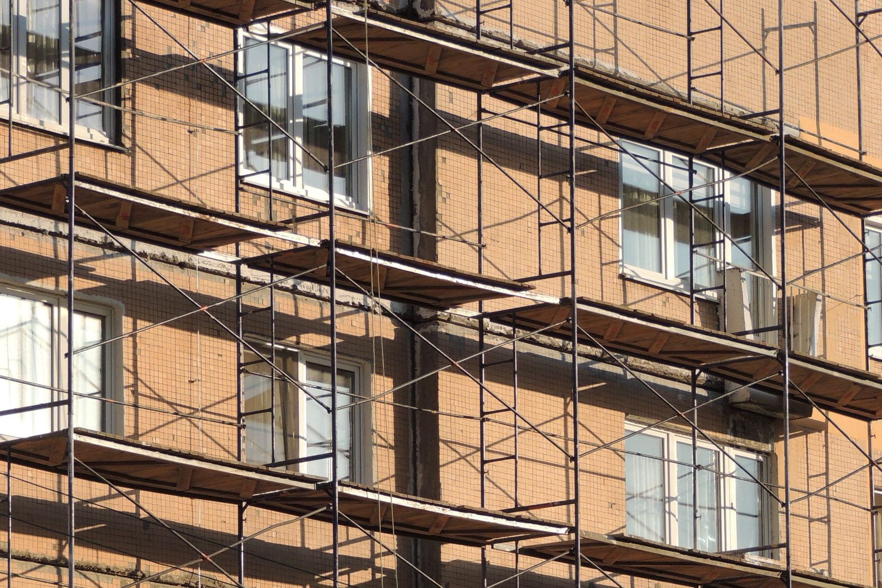 Façade échafaudée sur un immeuble, lumière du matin